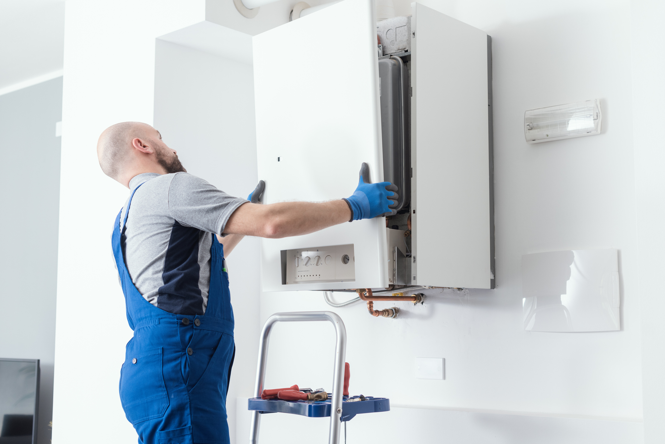 Home Comfort team member returning the front panel of a boiler after service